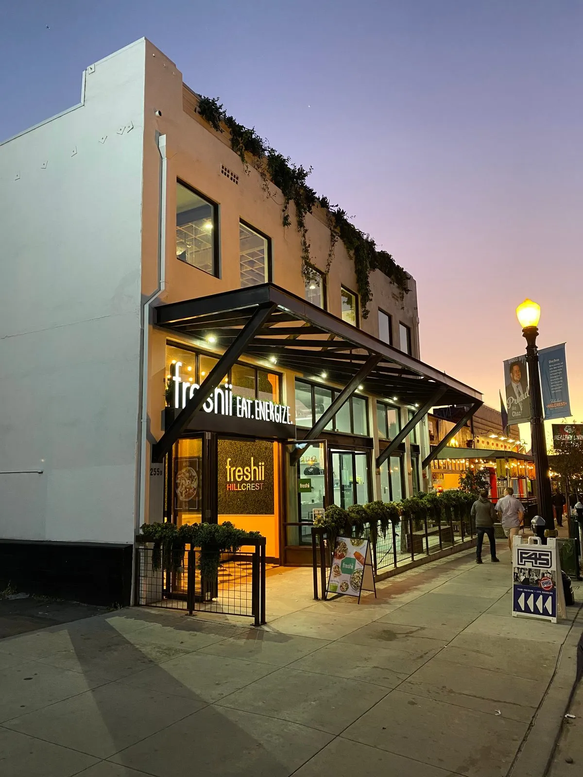 Retail storefront building at dusk on a busy Hillcrest street, San Diego
